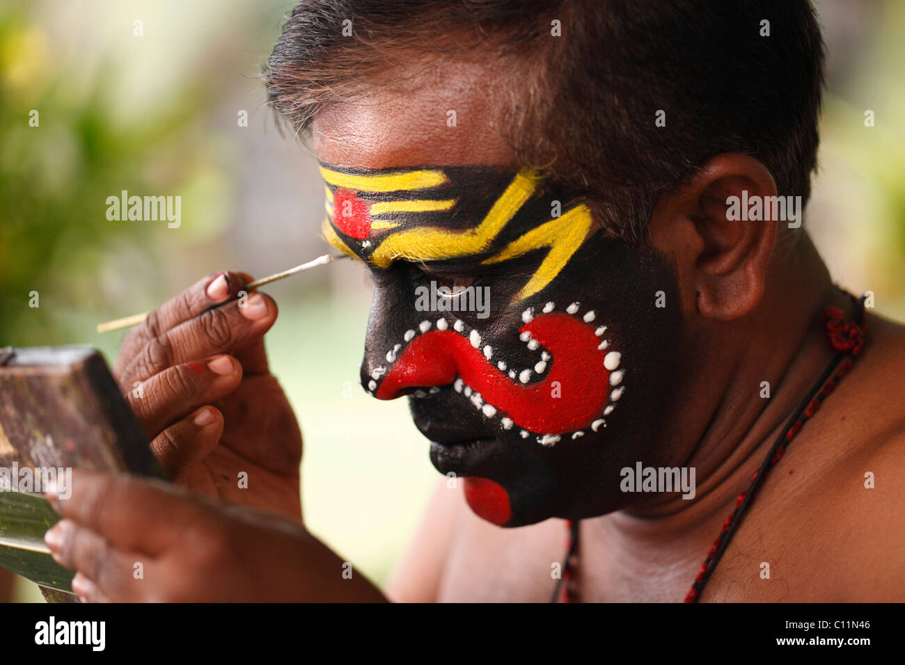 Kathakali dancer doing his make up, Chuvanna Thaadi mask, Kerala, southern India, Asia Stock Photo