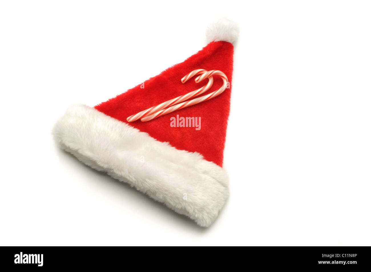 red Santa hat on white background with candy canes Stock Photo