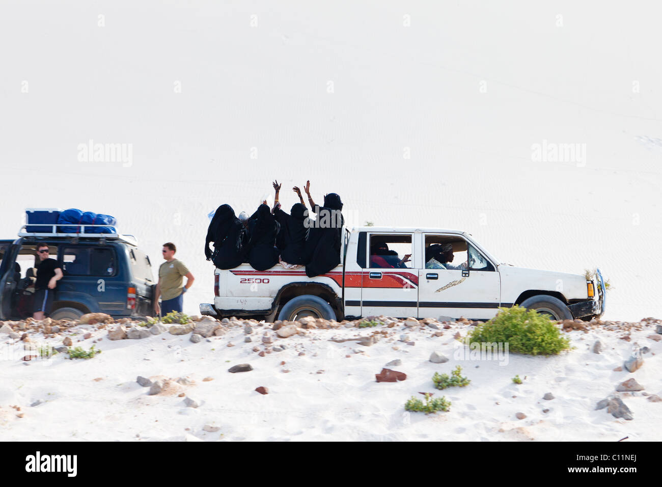 Birkha Clad ladies wave to a tourist on Socotra Stock Photo
