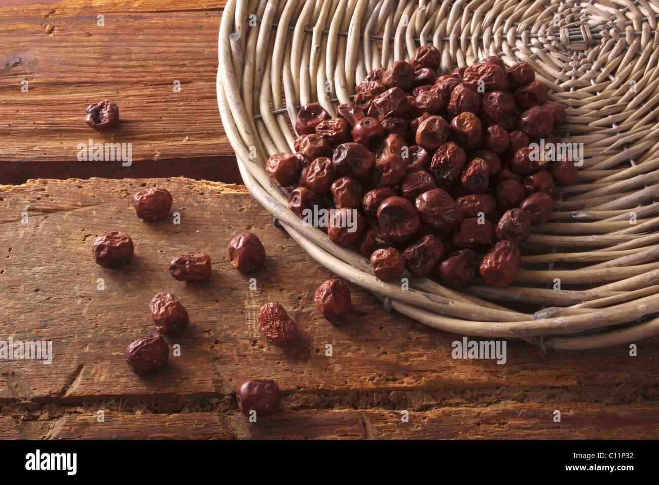 Dried Jujube berries (Ziziphus jujuba) as an ingredient for breakfast cereals, cakes and pastries, tipped out of a willow basket Stock Photo