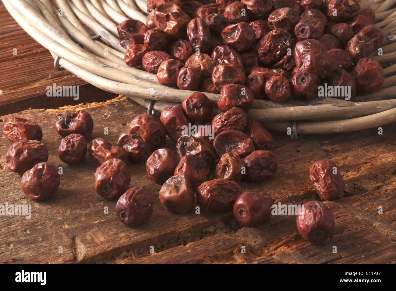 Dried Jujube berries (Ziziphus jujuba) as an ingredient for breakfast cereals, cakes and pastries, tipped out of a willow basket Stock Photo