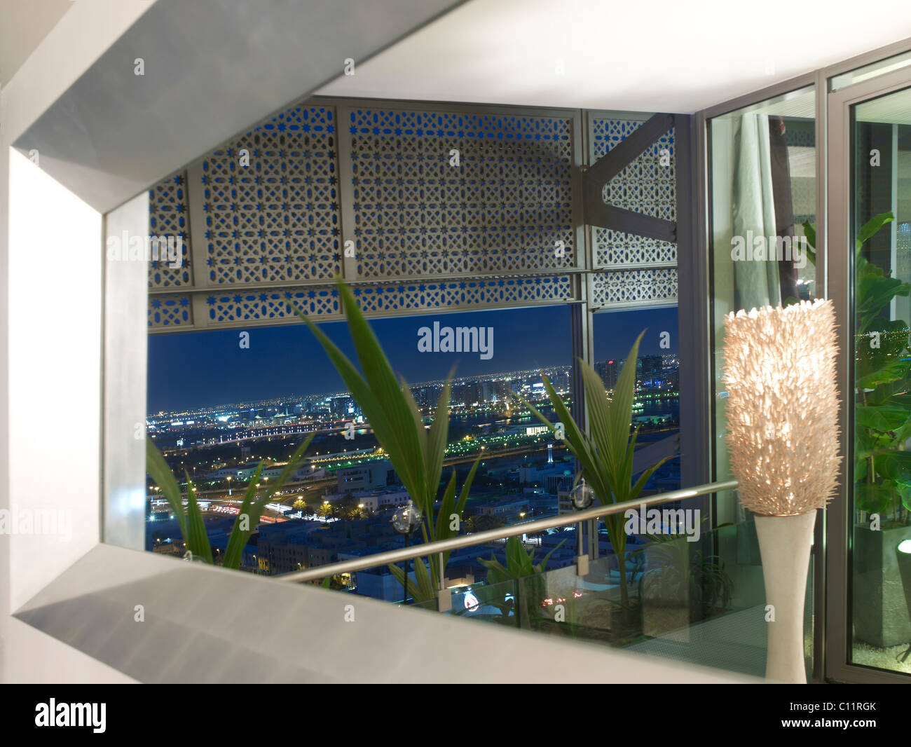 View of Dubai at night through silver luxurious mirror in a loft