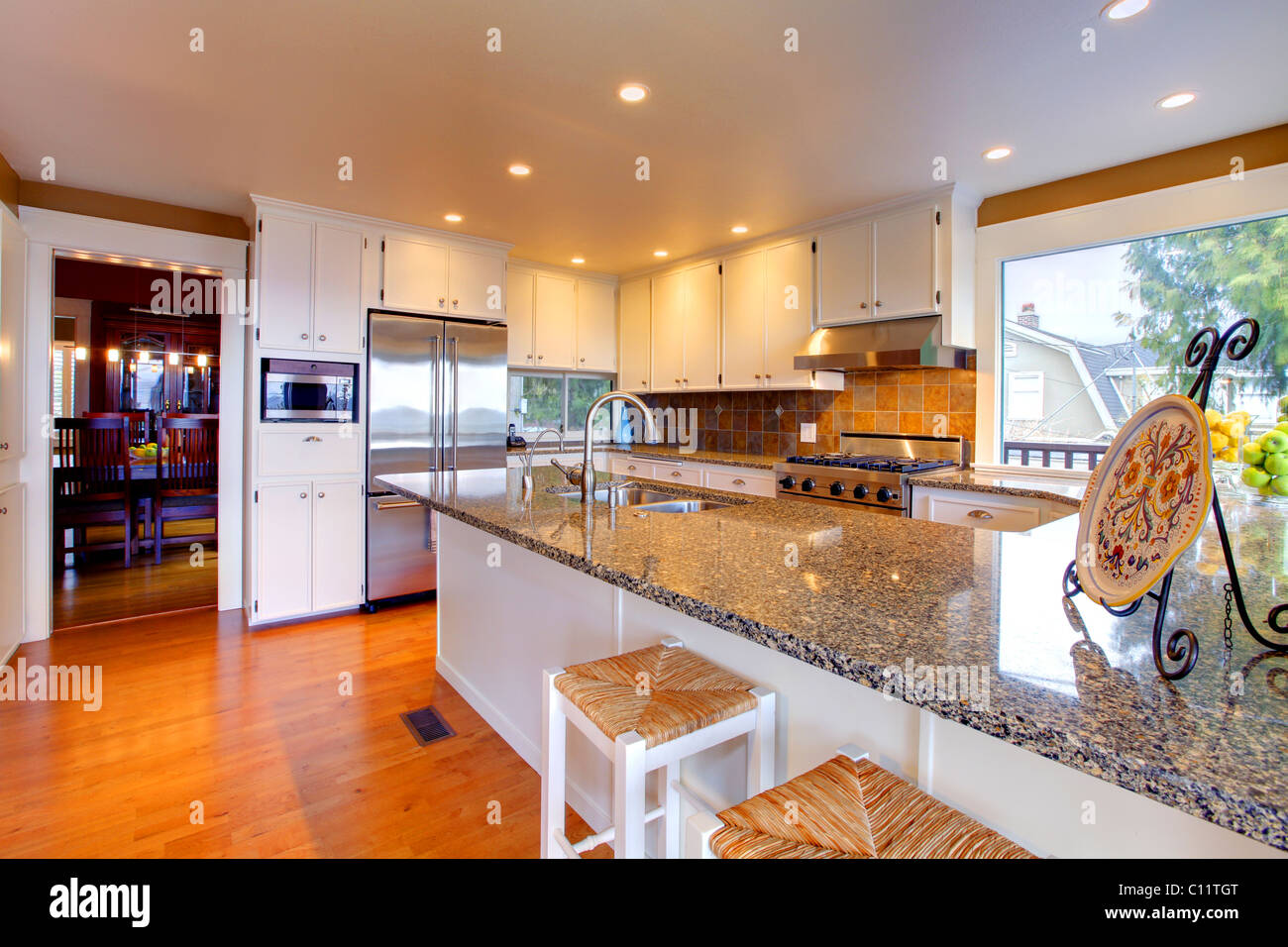 Luxury white kitchen, oak floors and beautiful granite Stock Photo