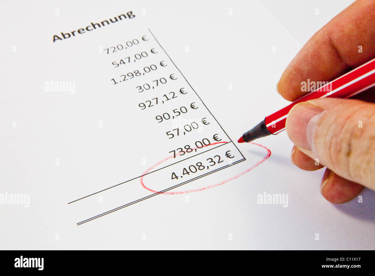 A hand marking an amount in a bill Stock Photo
