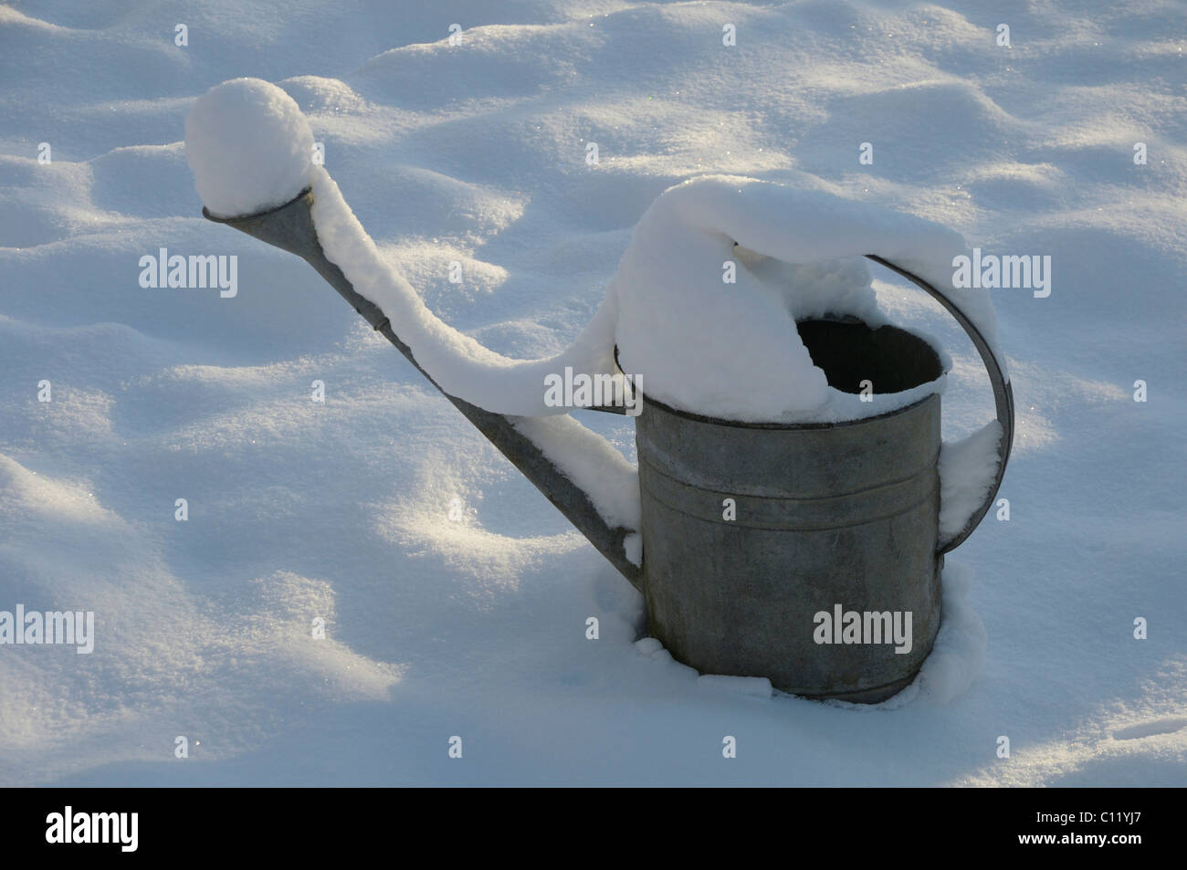 Watering can in the snow Stock Photo