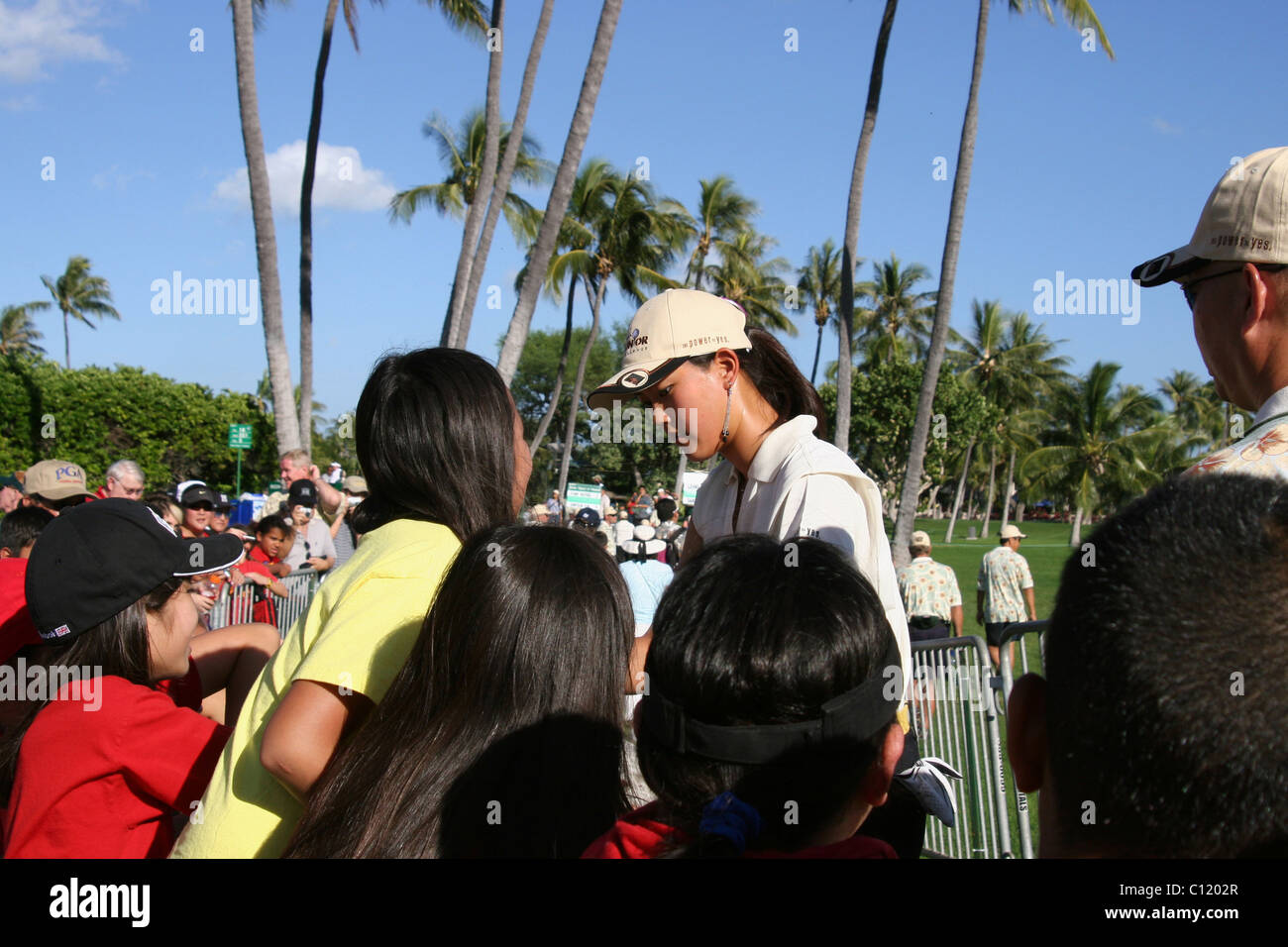 Fifteen year old child golf star Michelle Wie is signing autographs for golf fans prior to the PGA 2005 Sony Open In Hawaii. Stock Photo