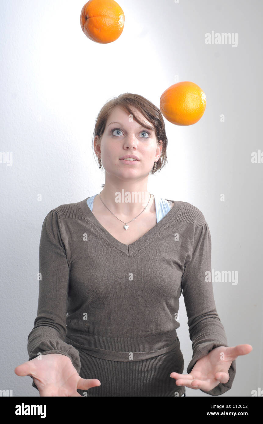 Young woman juggling with two oranges Stock Photo Alamy