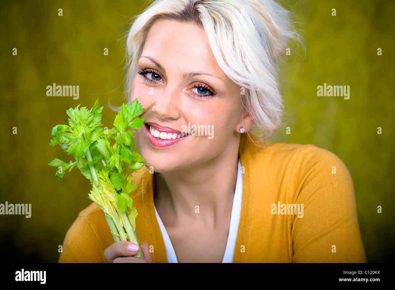 Young woman holding a stick of celery Stock Photo