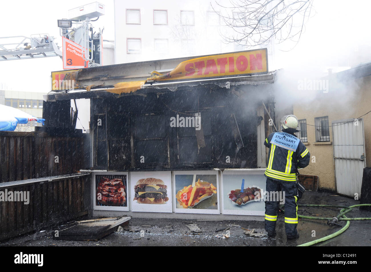 Fire brigade extinguishing a fire in a burnt-out snack stand, Stuttgart ...