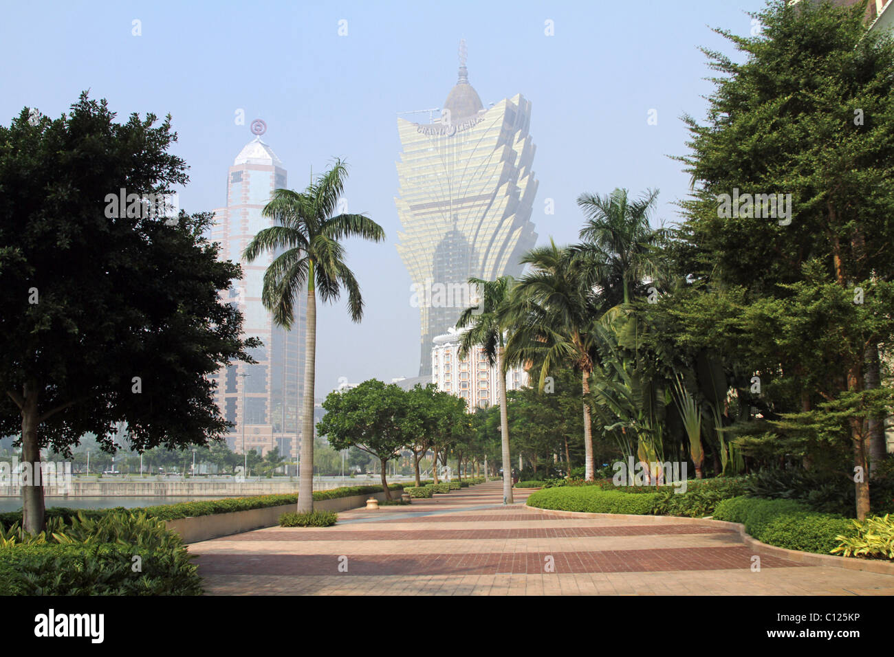 Skyline of the Grand Lisboa Casino and Hotel and Bank of China building with palm trees along the waterfront in Macau, China. Stock Photo