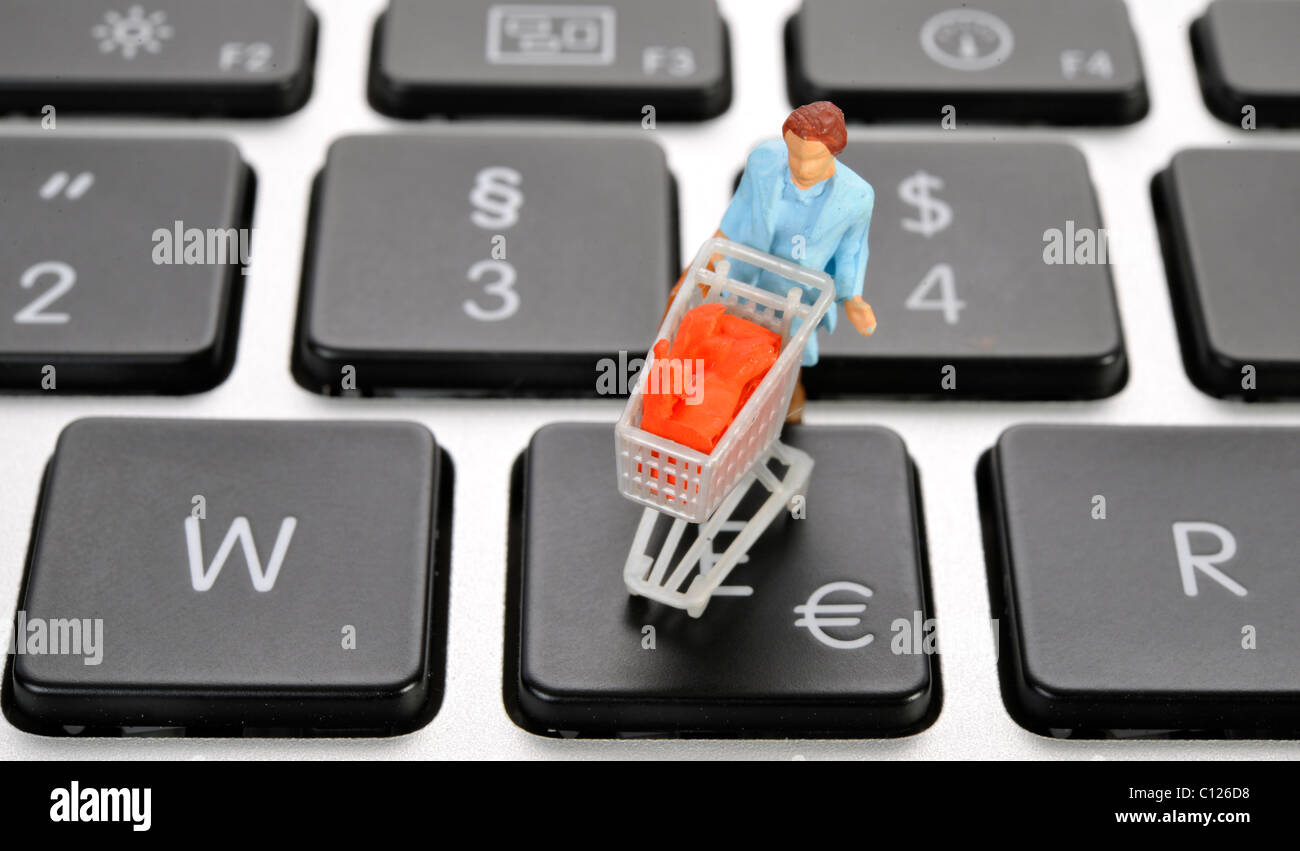 Miniature figure with cart on keyboard, euro symbol, symbolic picture for online shopping Stock Photo