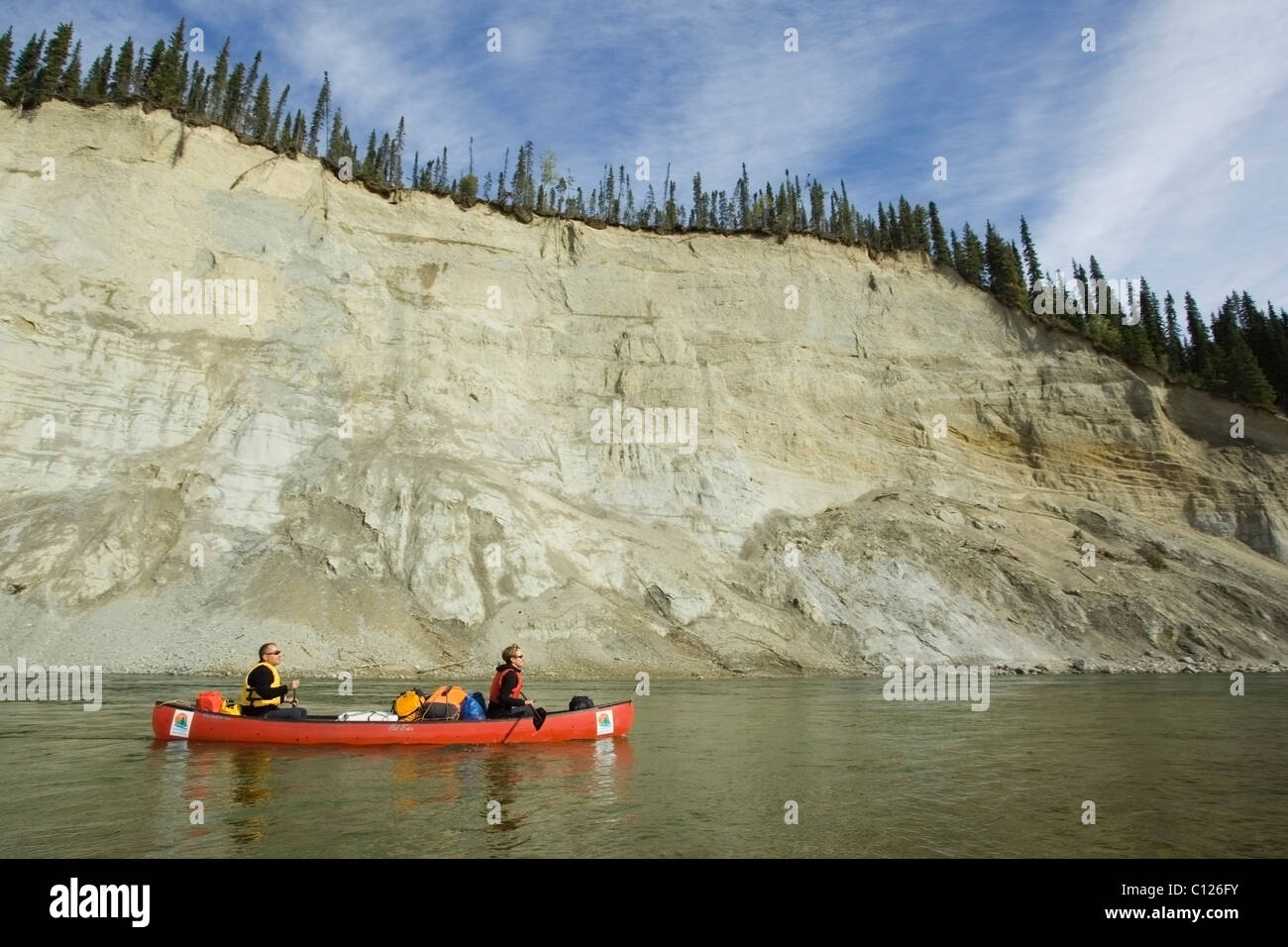 Couple, man and woman paddling a canoe, canoeing, river shaping landscape, erosion in soft sandstone, high cut bank, cliff Stock Photo