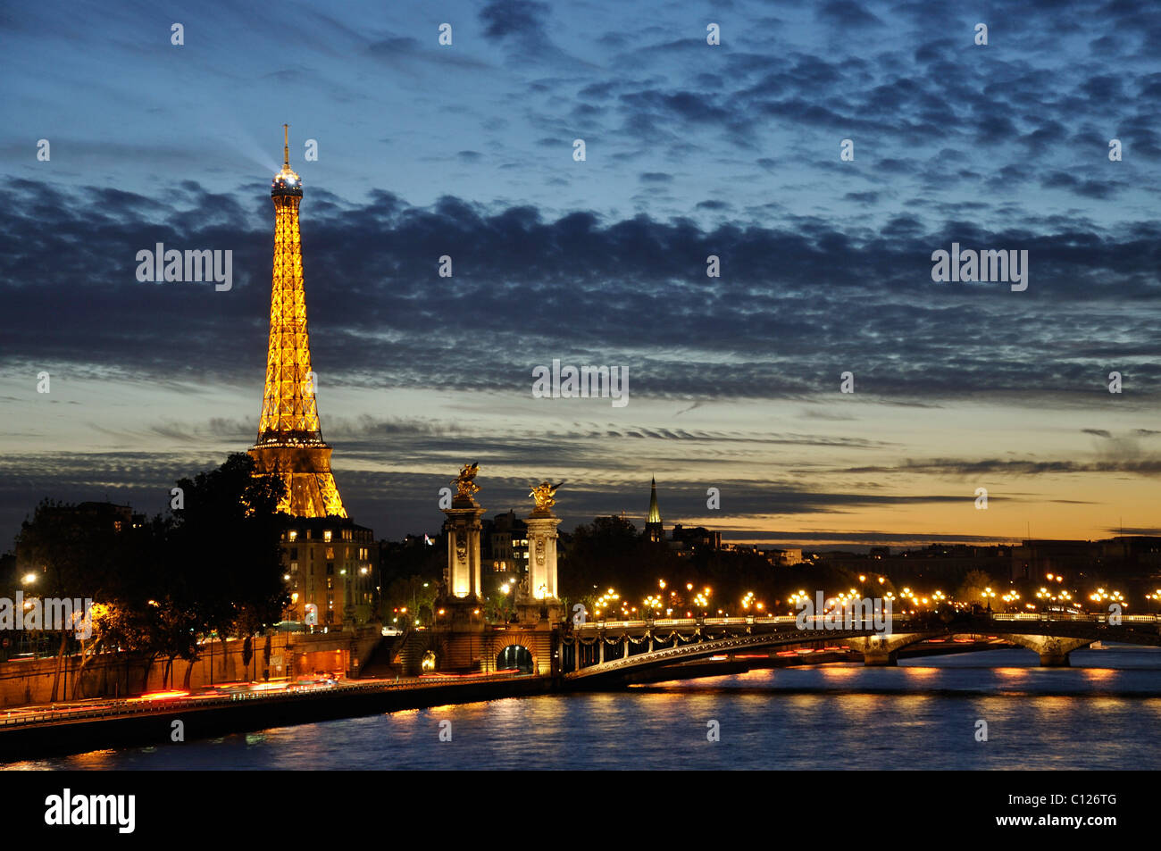 Eiffel Tower at night showing pont alexander bridge and river seine Stock Photo