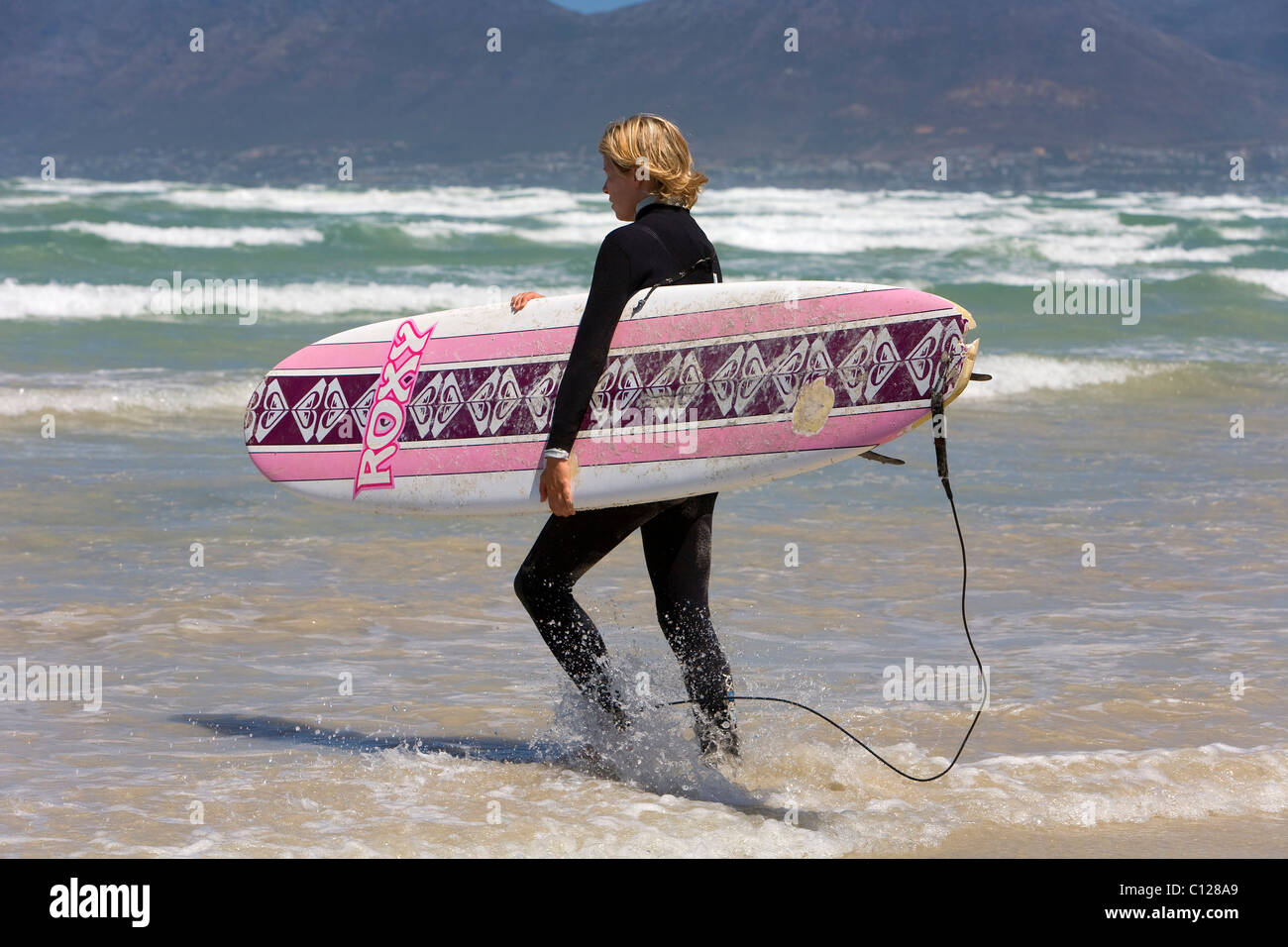Surfer with surfboard on the beach in Muizenberg, Cape Town, Western