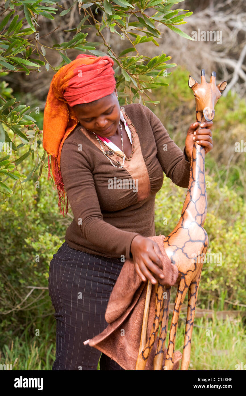 Woman cleaning a wooden giraffe, souvenir, Cape of Good Hope, Western