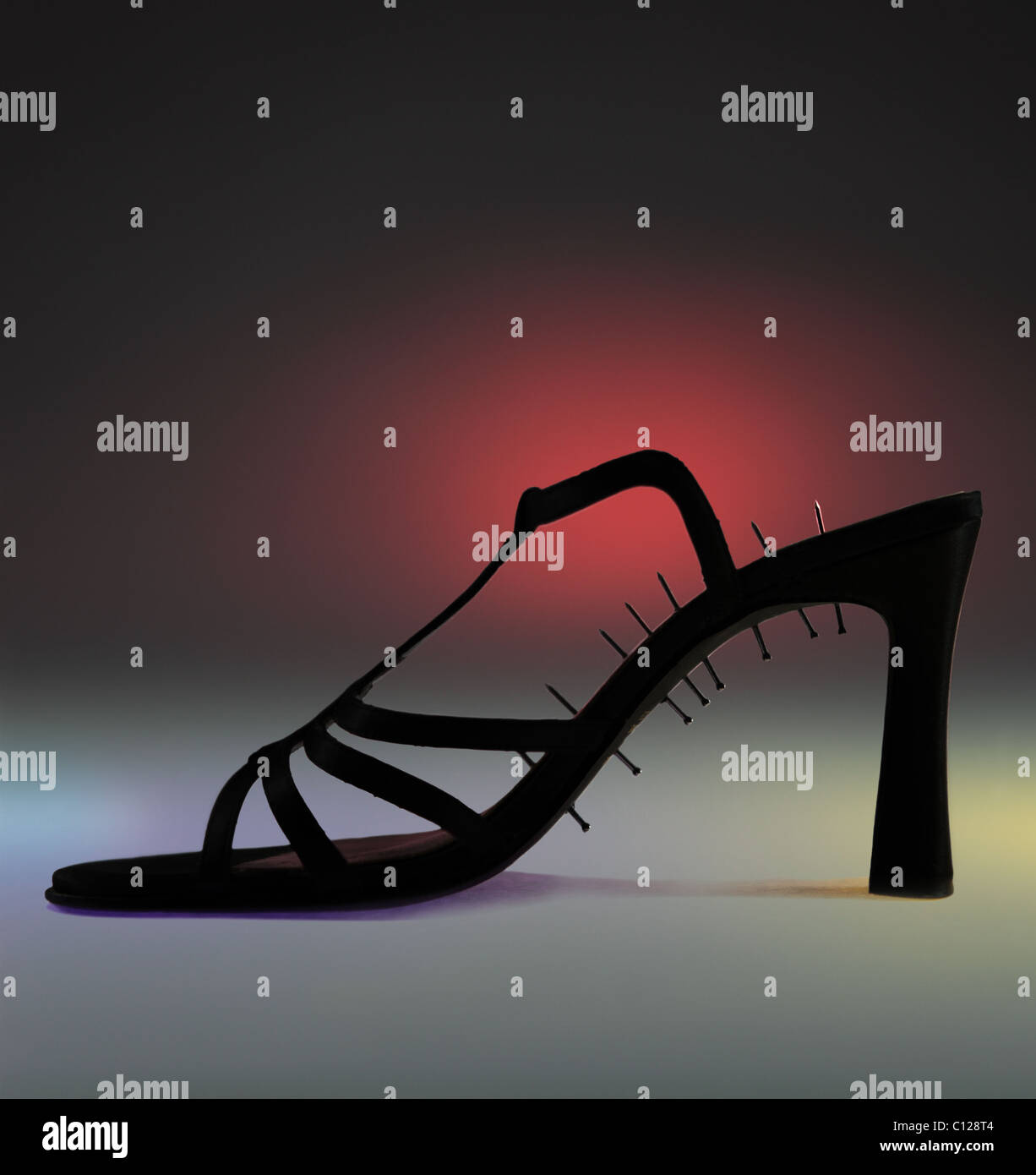 black high heel shoe. The sole is pierced by nails. This image symbolizes feet sore and high heeled shoes discomfort Stock Photo