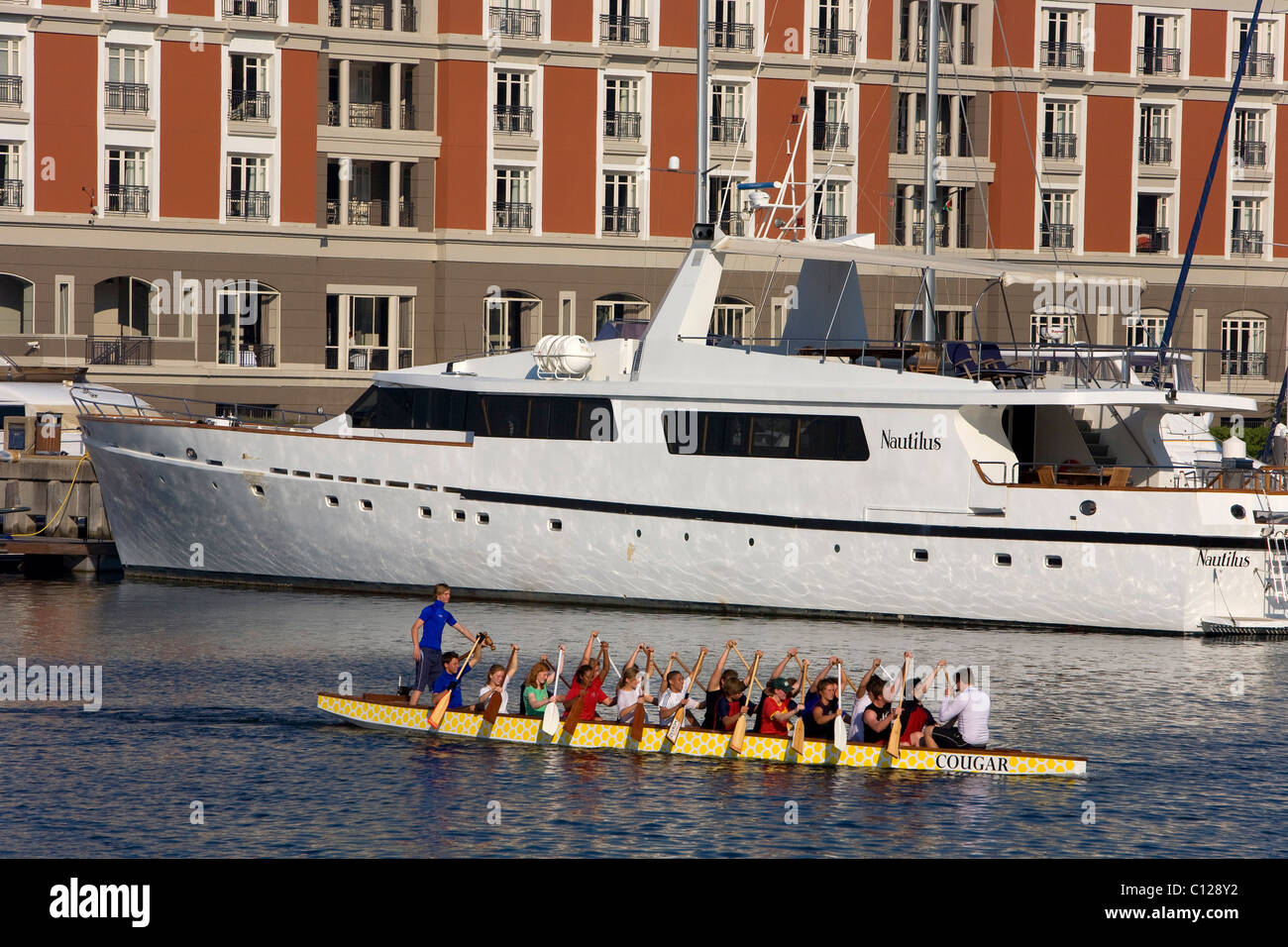 Luxury homes at the Waterfront, in front a luxury yacht, canoeists