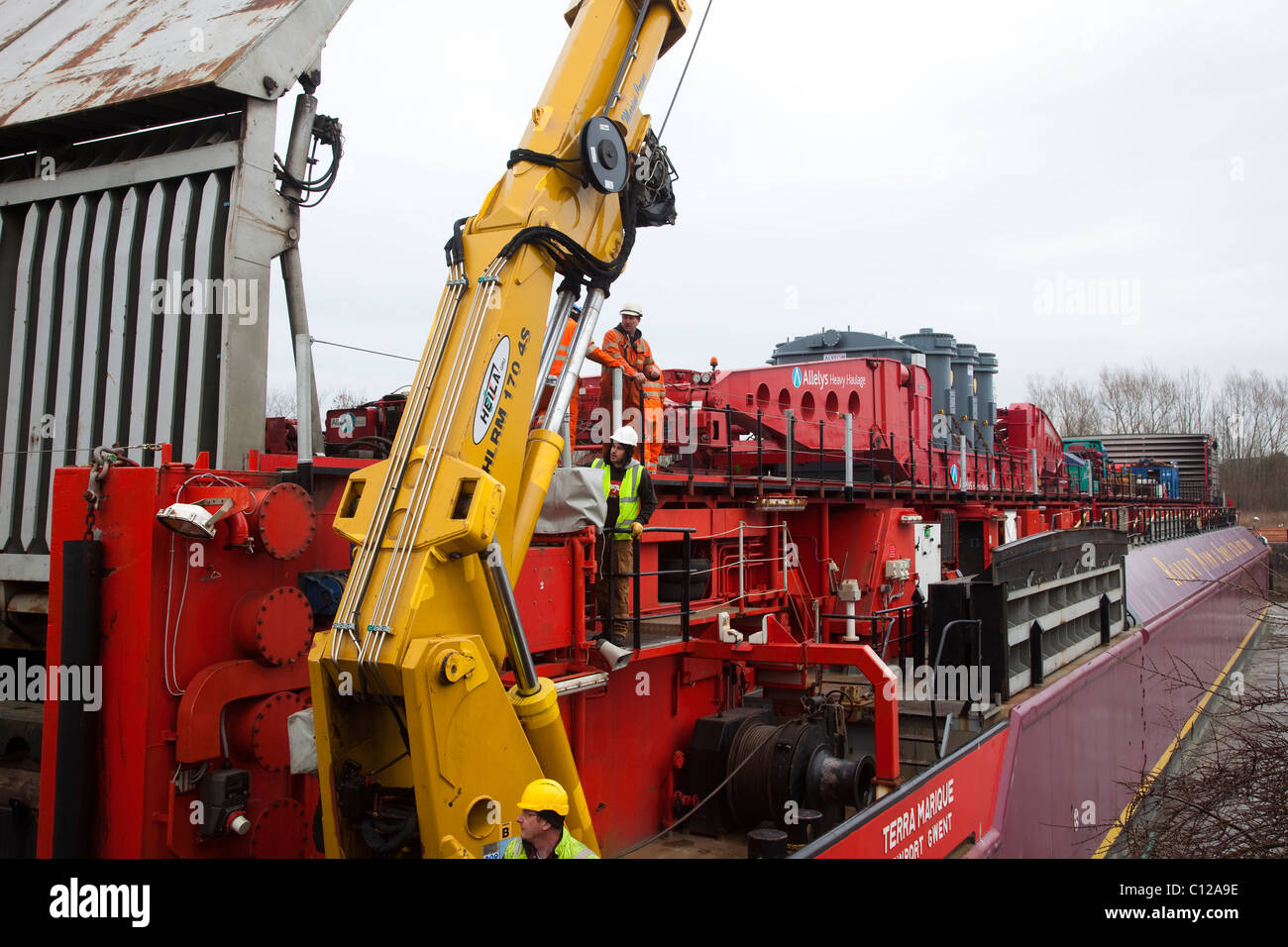 Workmen using Hydraulic equipment to delivery the Alstom National Grid Transformer,  Preston from the barge Terra Marique on the River Ribble, Lancashire, UK Stock Photo