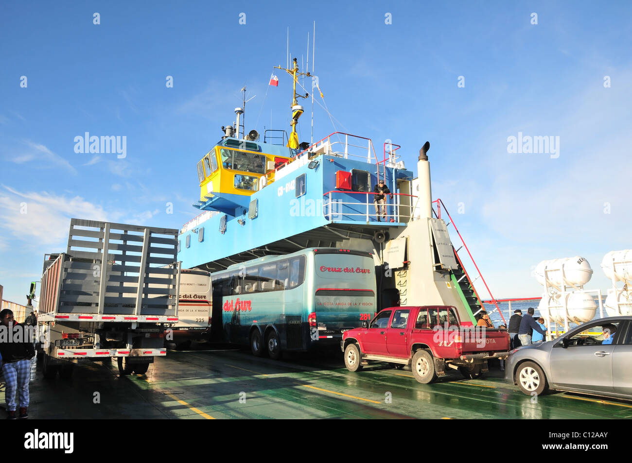 Blue sky view of green vehicle deck carrying cars buses lorry and