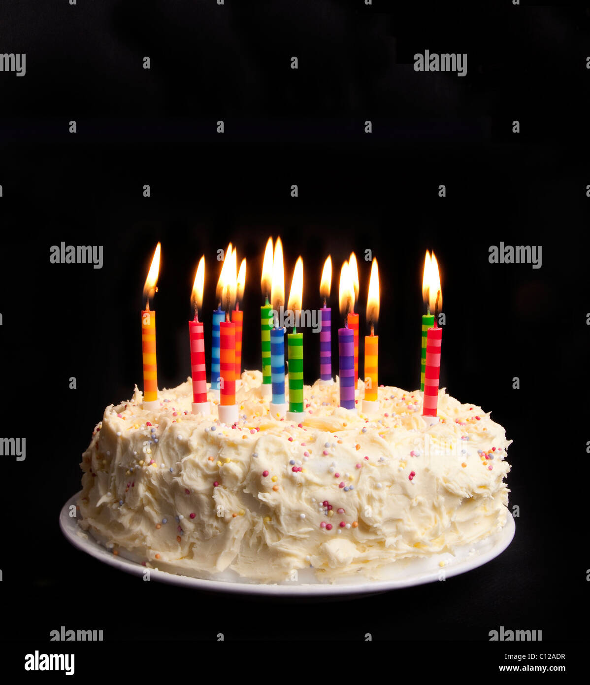 cake on a black background with candles alight Stock Photo