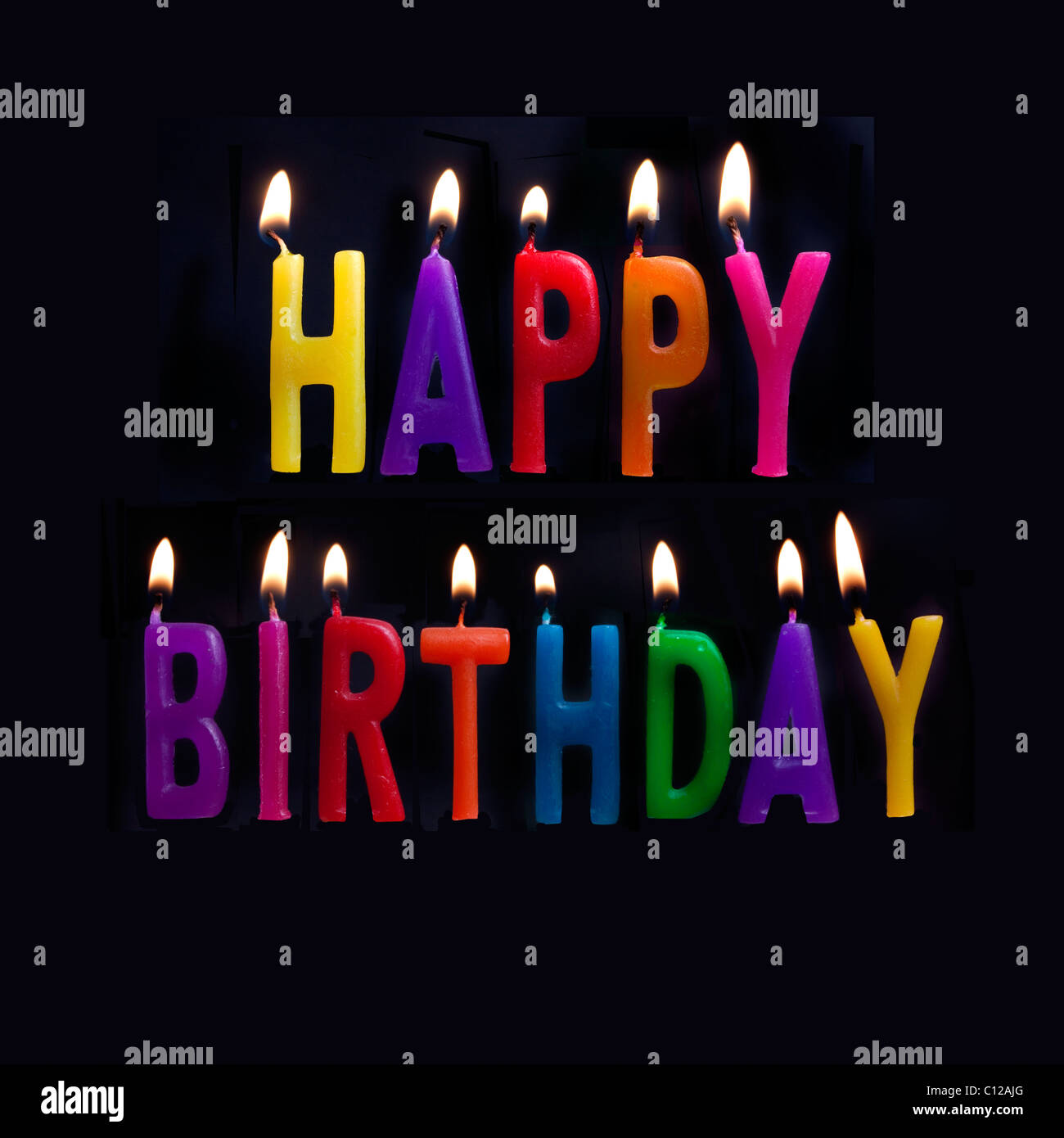 HAPPY BIRTHDAY MESSAGE IN ENGLISH WITH CANDLES ALIGHT Stock Photo