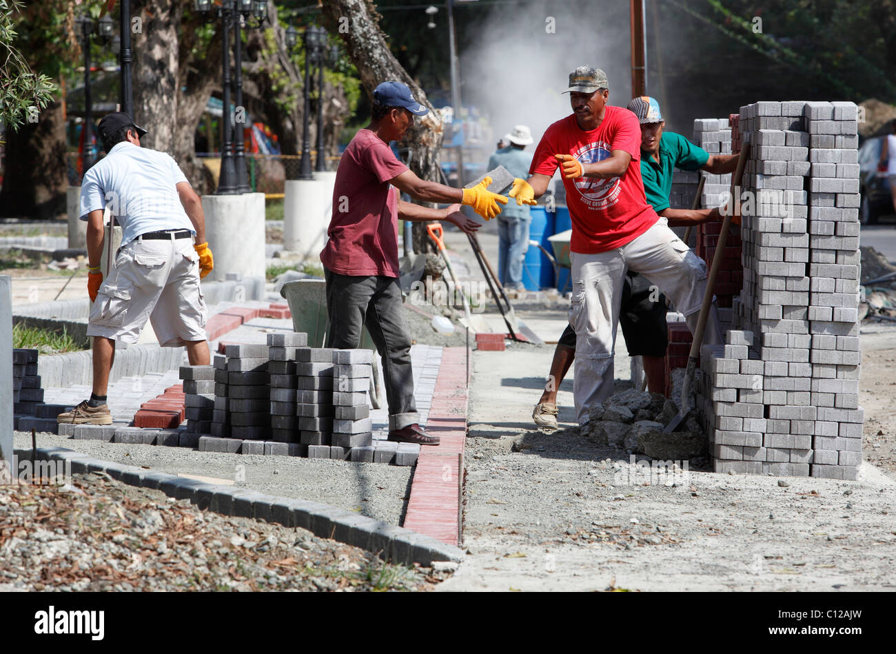 Workers construct a sidewalk in Quepos, Costa Rica Stock Photo