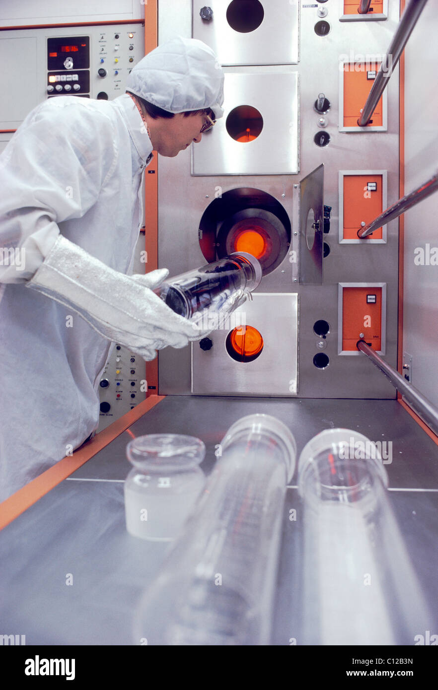 Male technician prepares to load silicon wafers into an oven, part of the production process in making computer micro chips Stock Photo