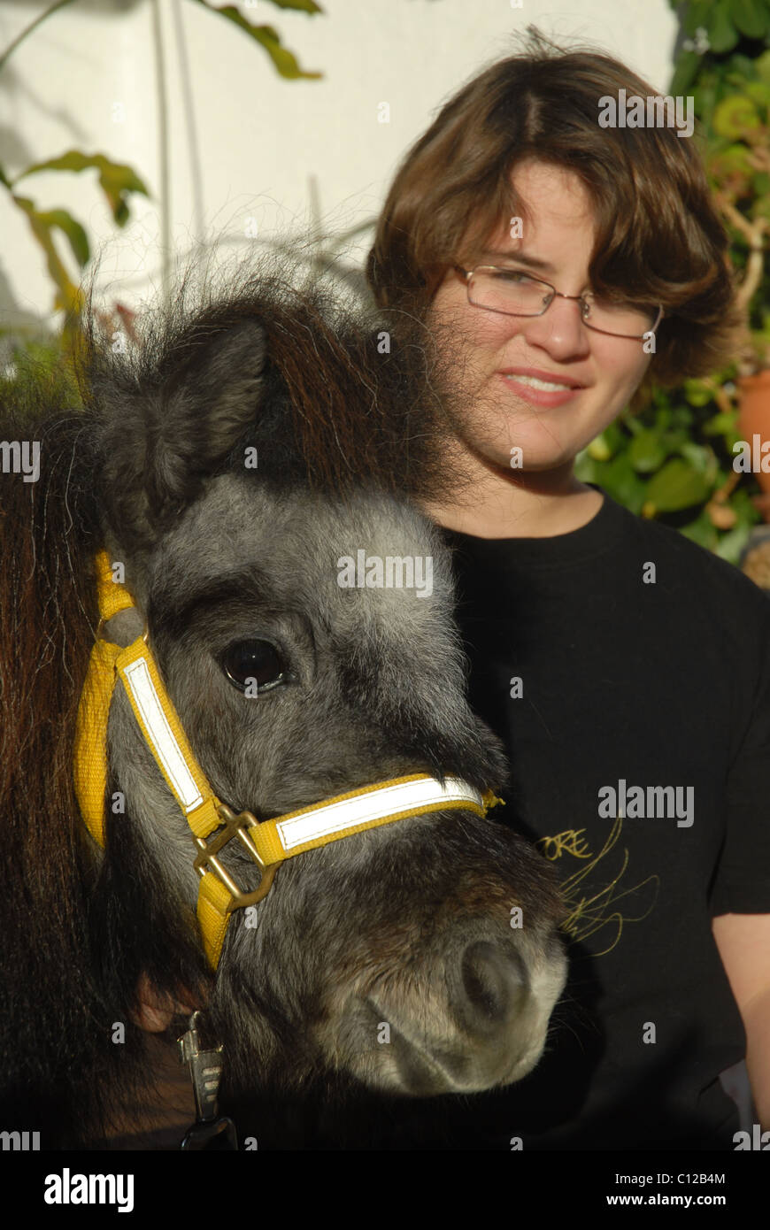 girl (aged 12) with pet Falabella miniature horse Stock Photo