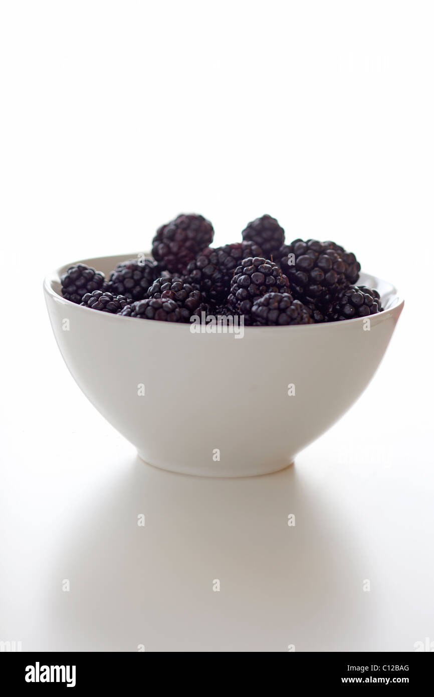 White bowl of blackberries on white Stock Photo