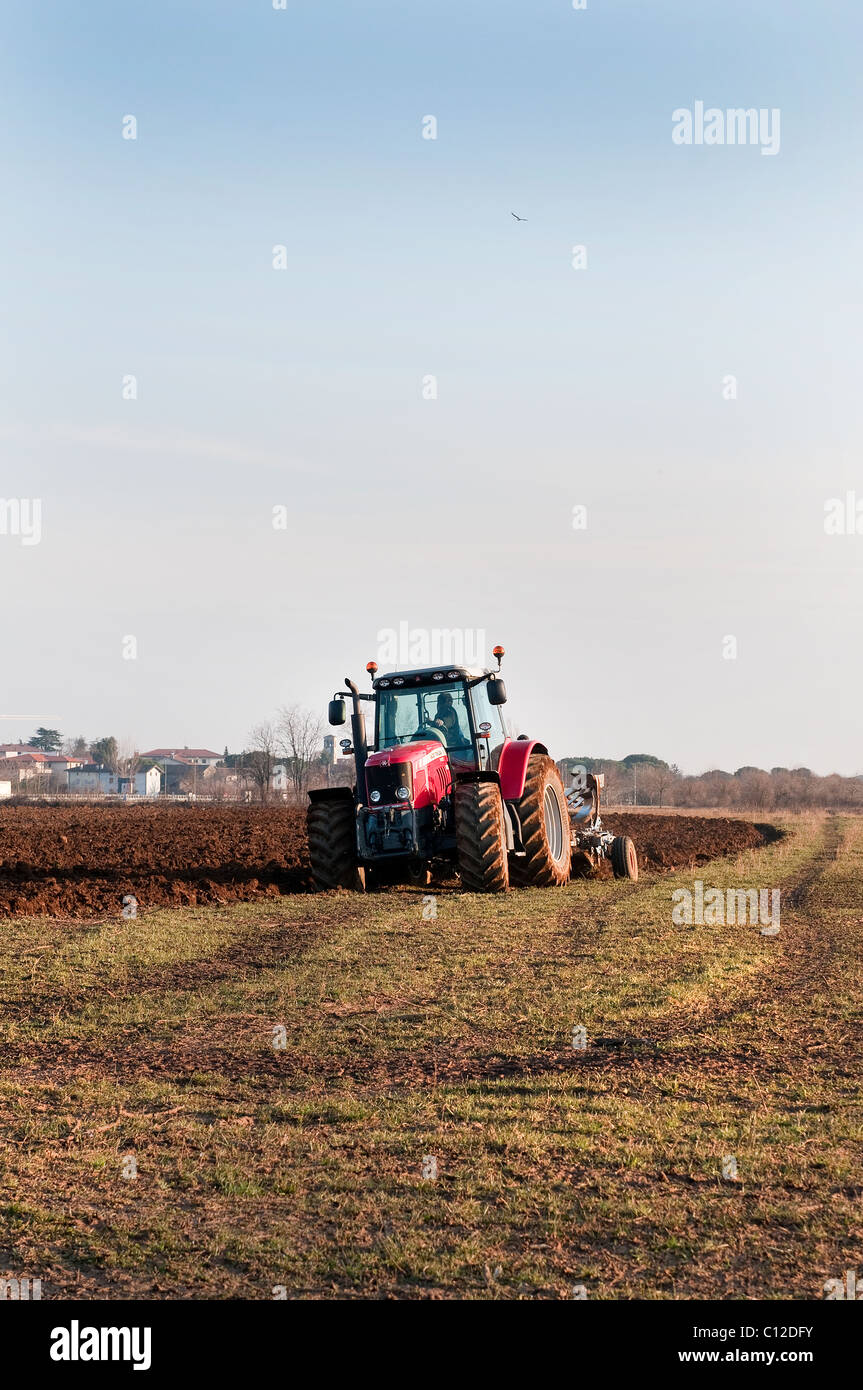 a tractor plowing a field Stock Photo