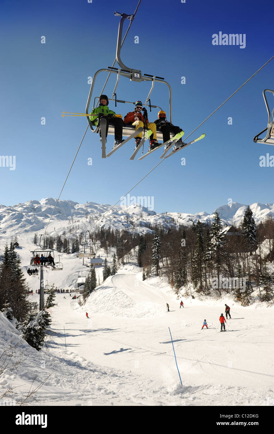 Skiers on a chair lift at the Vogel Ski Centre in the Triglav National Park of Slovenia Stock Photo