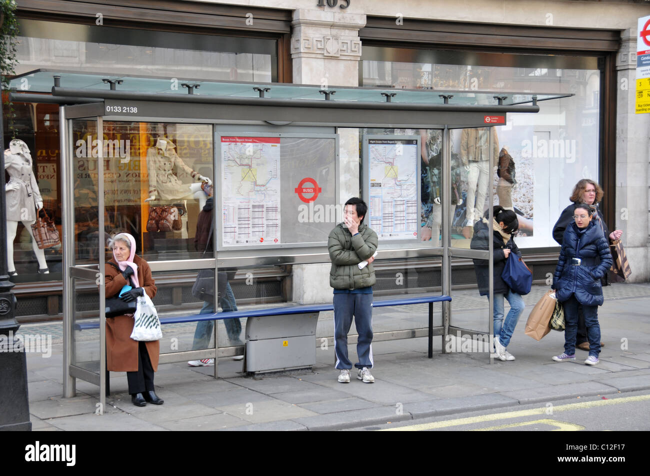 Bus stop waiting bored passengers London Transport commuters wait cold