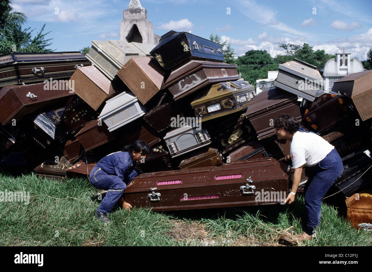 Aid workers move caskets for some of the 25,000 dead after the eruption