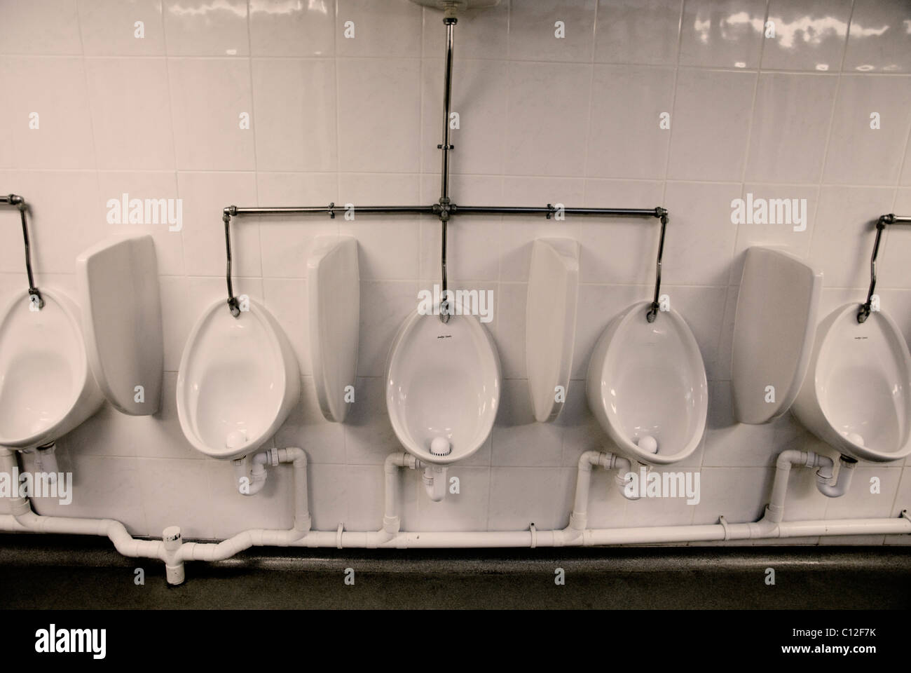 Men's urinals on white tiles Stock Photo