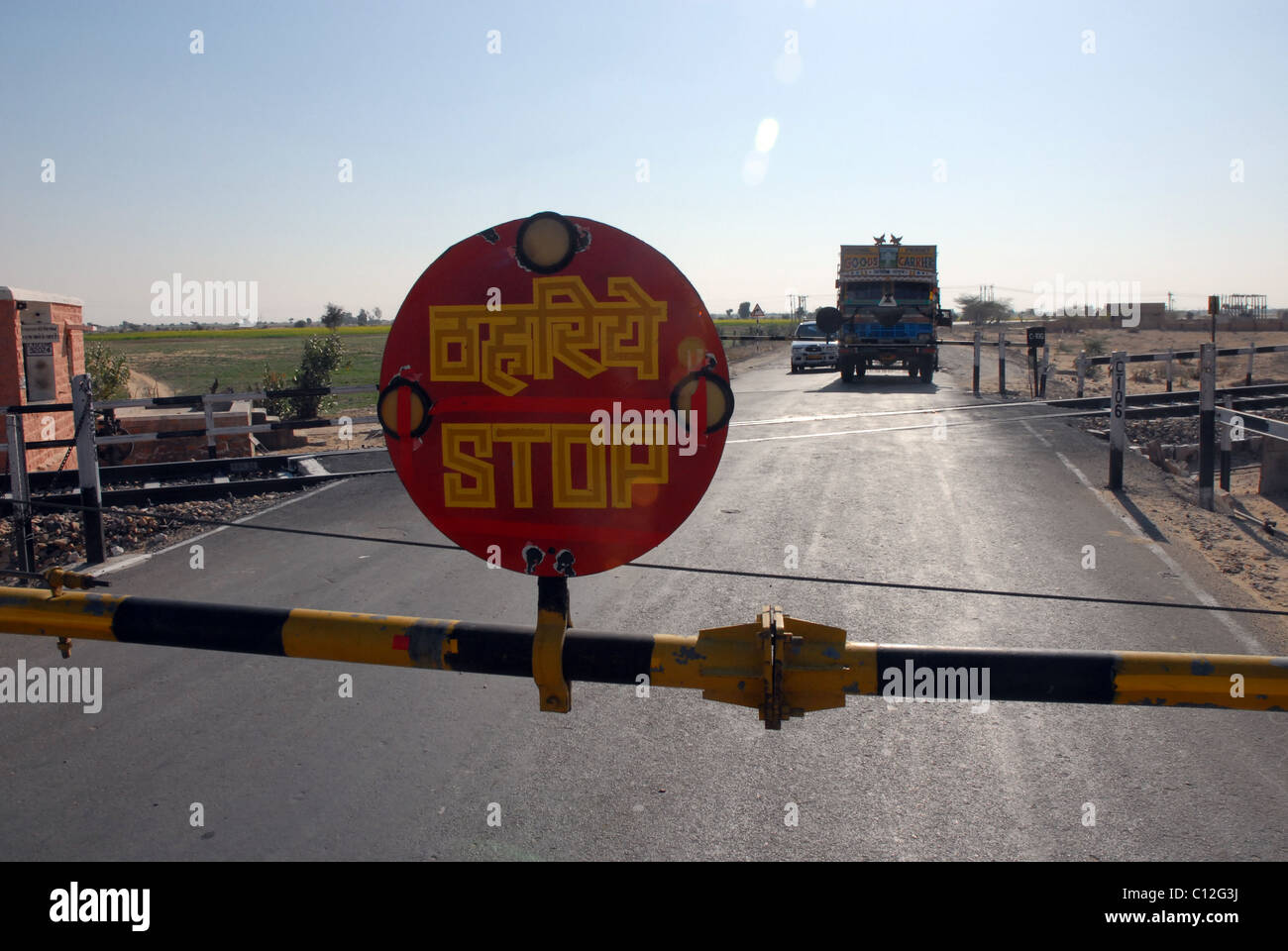 Lorry, truck at level-crossing with STOP sign in Rajasthan, India Stock Photo