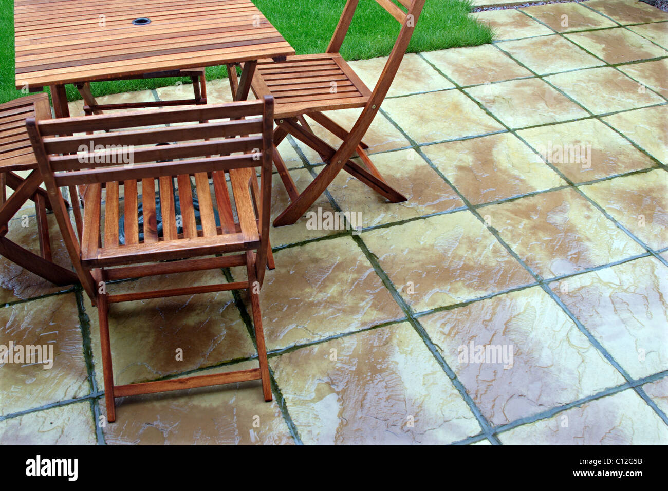 Wooden garden Furniture on patio in the rain Stock Photo Alamy