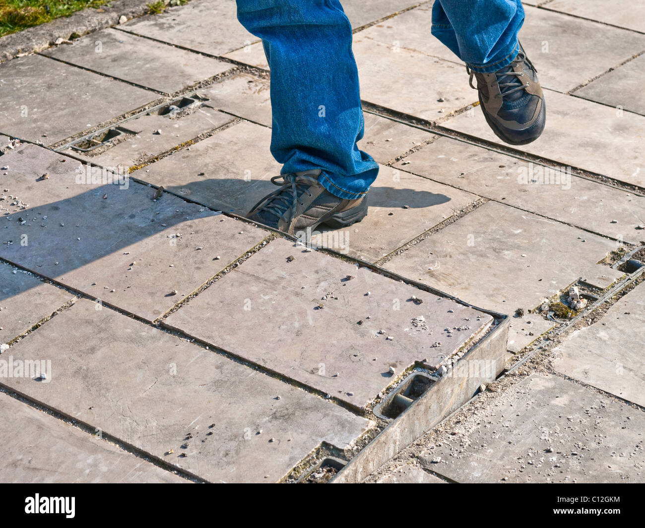 Pedestrian in danger of tripping on unseated grid cover - France. Stock Photo