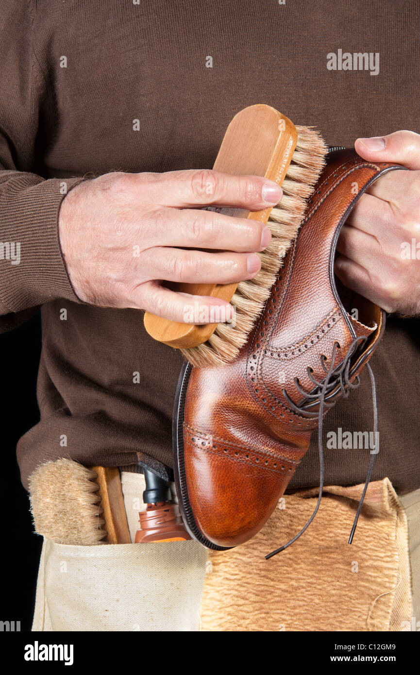 A shoe shiner works on the final buffing of a leather dress shoe Stock Photo