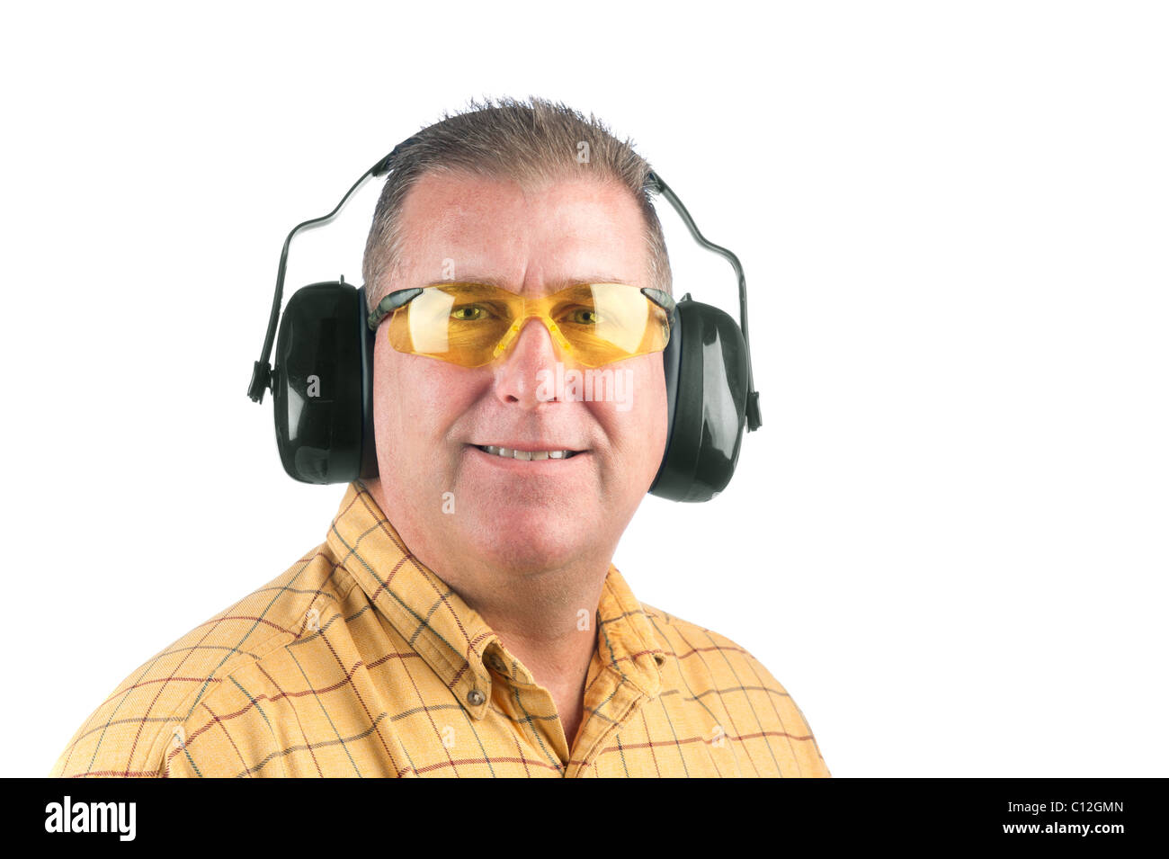 A worker wearing yellow safety glasses and hearing protection. Stock Photo
