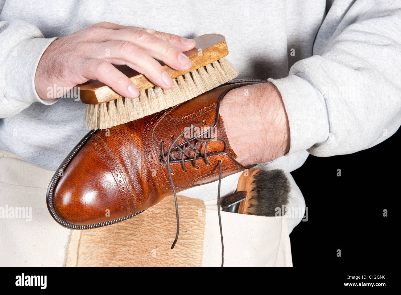 A shoeshine man polishing a leather dress shoe Stock Photo