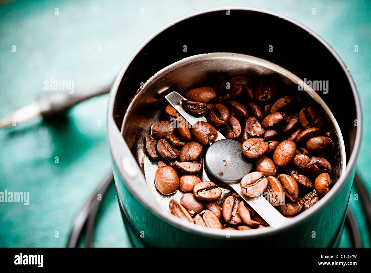 https://c8.alamy.com/comp/C12GYW/electrical-coffee-mill-machine-with-roasted-coffee-beans-on-the-green-C12GYW.jpg