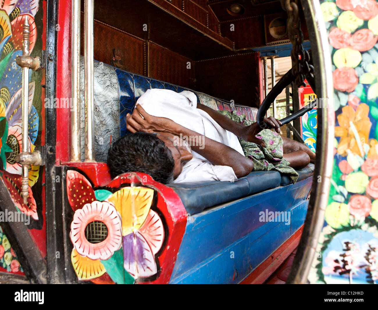 A truck driver asleep at the wheel, Kerala, India Stock Photo