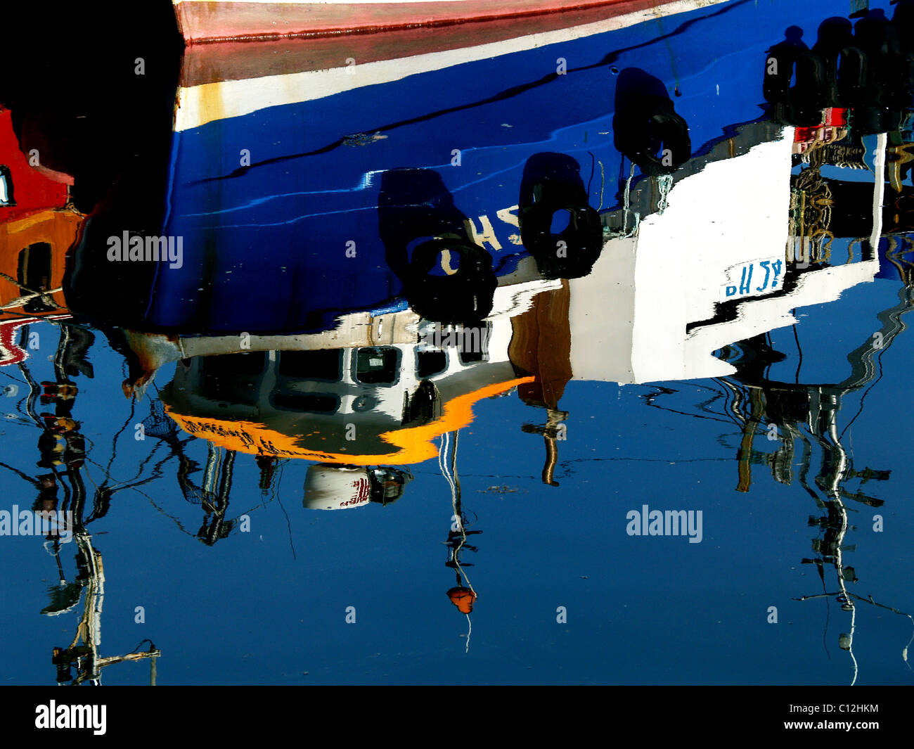 A fishing boat reflected in the Harbour of the Scottish Highland town of Cromarty Stock Photo