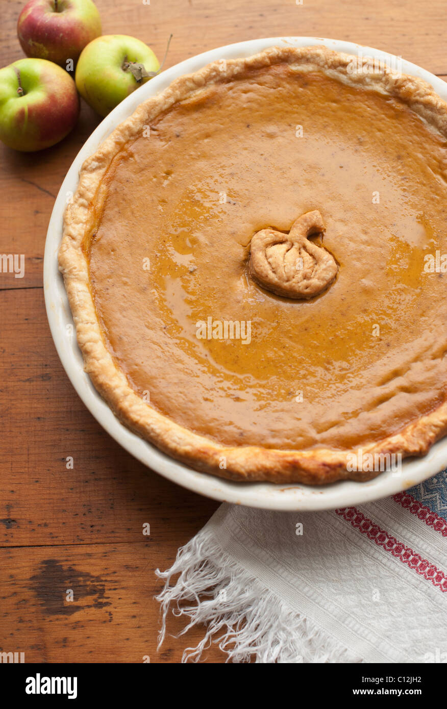 Close up of pumpkin pie and apples on table Stock Photo