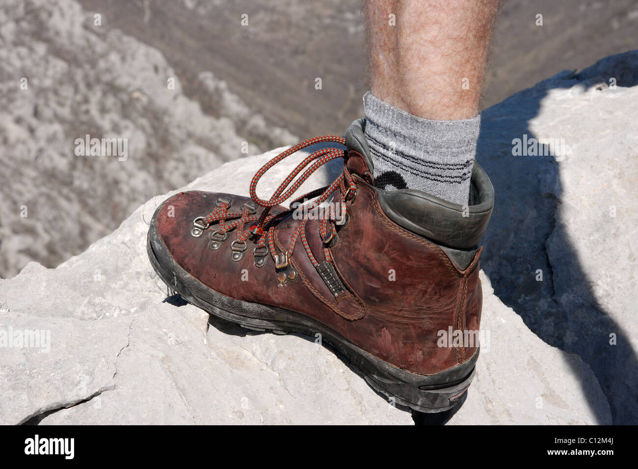 Brown worn out boot stepping on a rock Stock Photo - Alamy