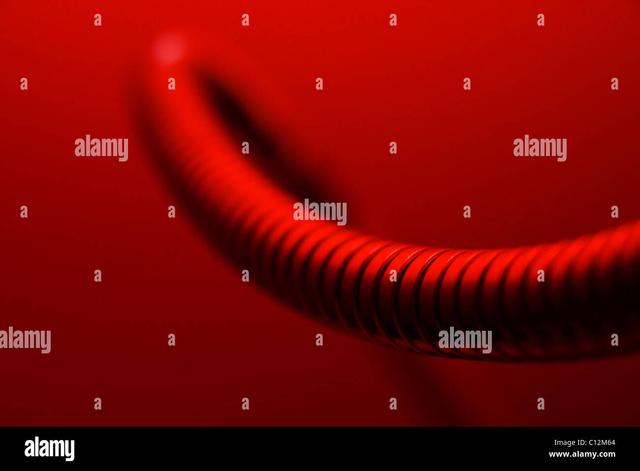 Abstract shape of a metallic tube in red light Stock Photo