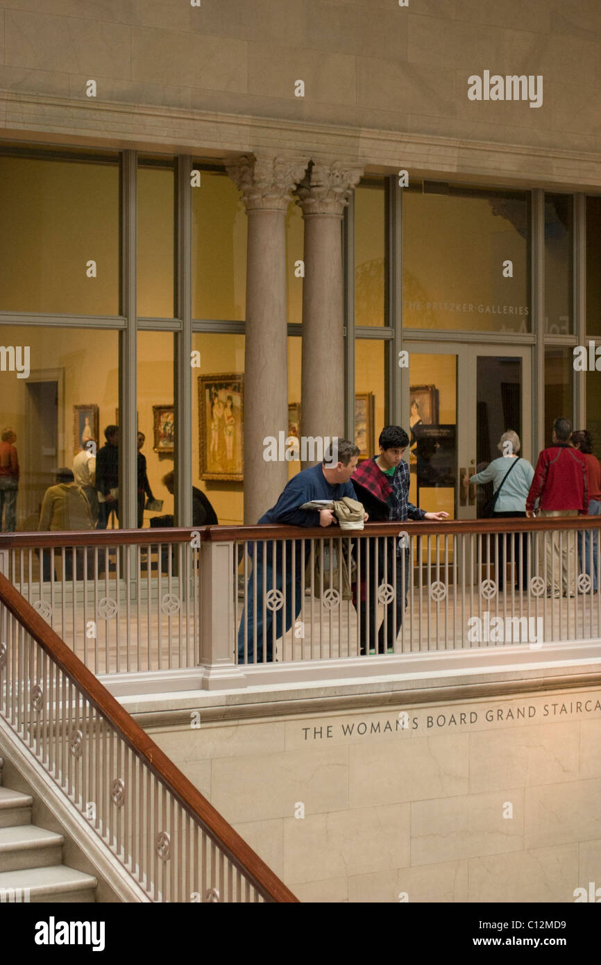 People lean on the bannister of the Woman's Board Grand Staircase at the Chicago Art Institute. Stock Photo