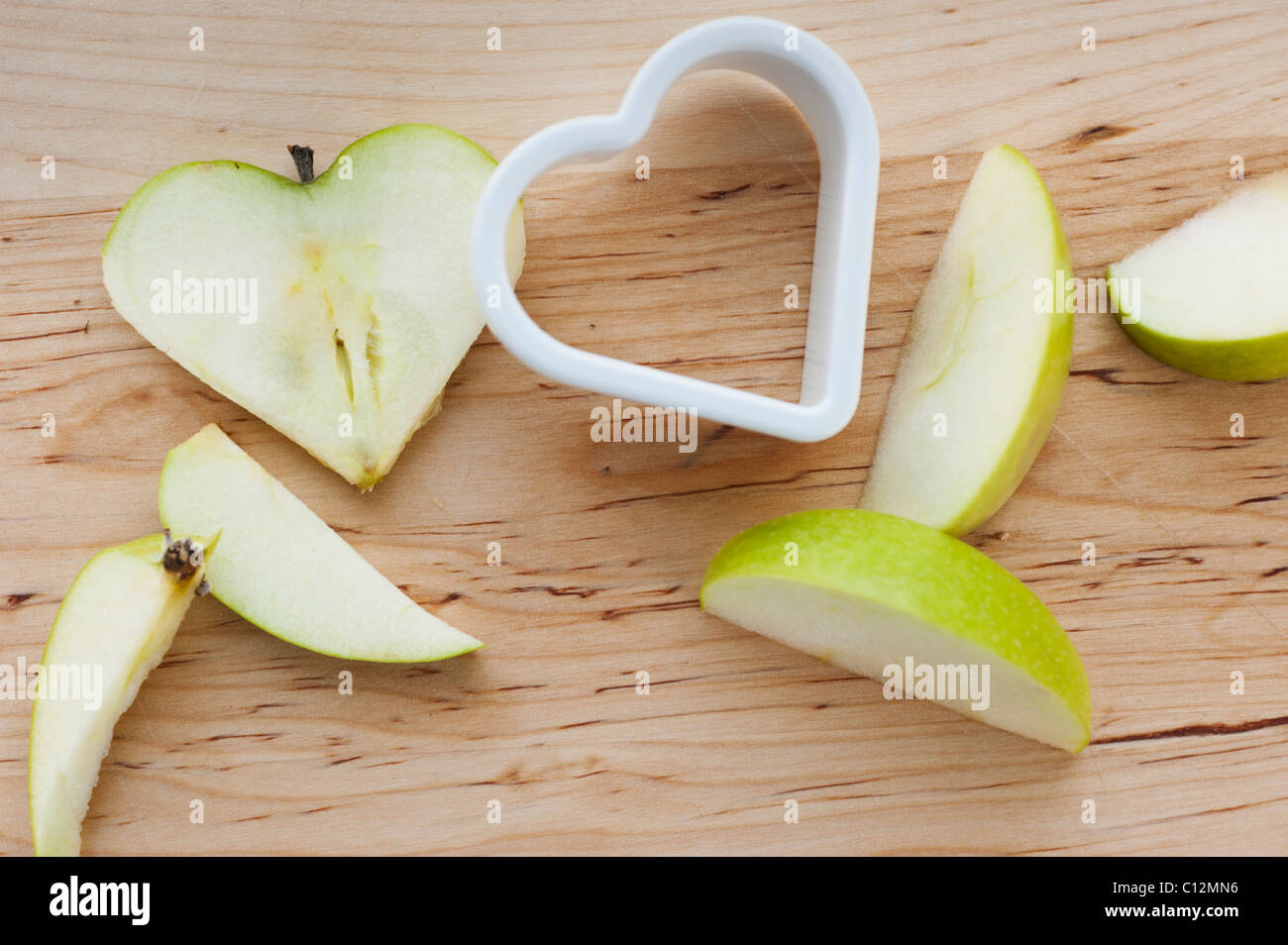 https://c8.alamy.com/comp/C12MN6/heart-shaped-apples-with-cutter-on-chopping-board-C12MN6.jpg