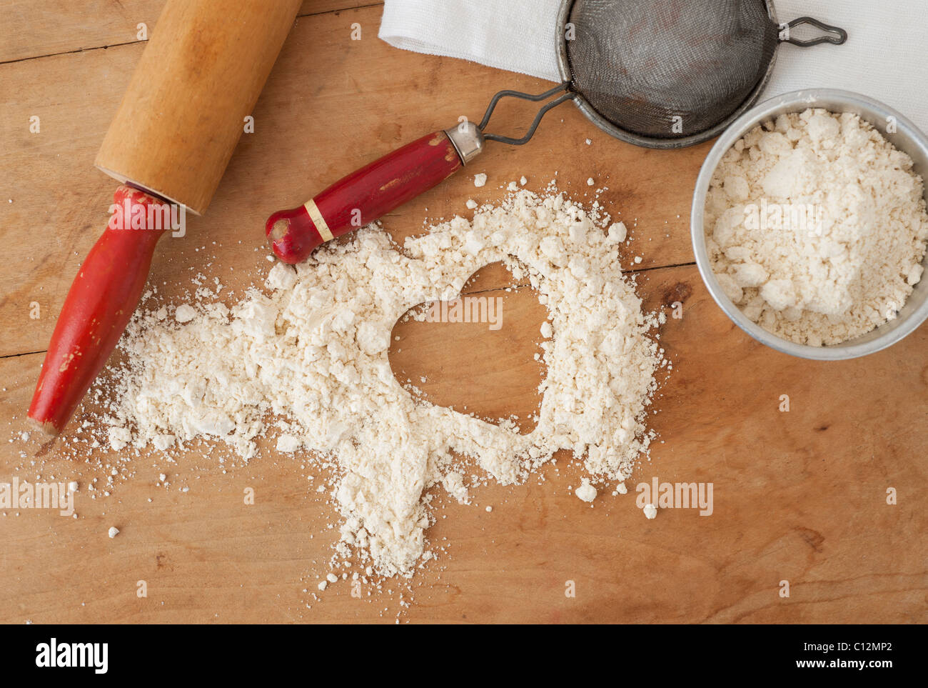 Heart shape in flour with baking utensils Stock Photo