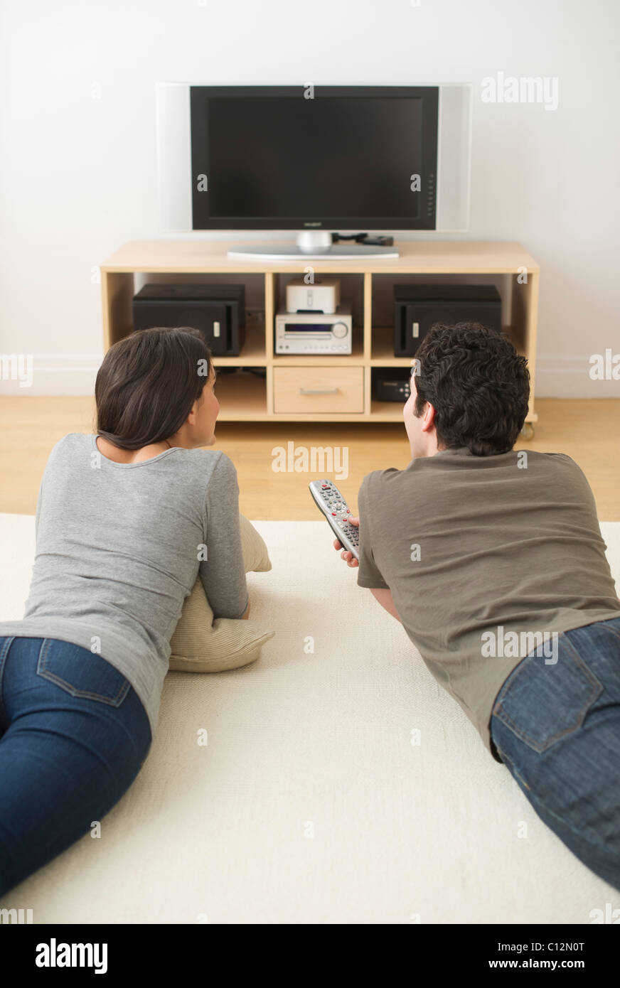 USA, New Jersey, Jersey City, couple lying on floor watching tv Stock Photo